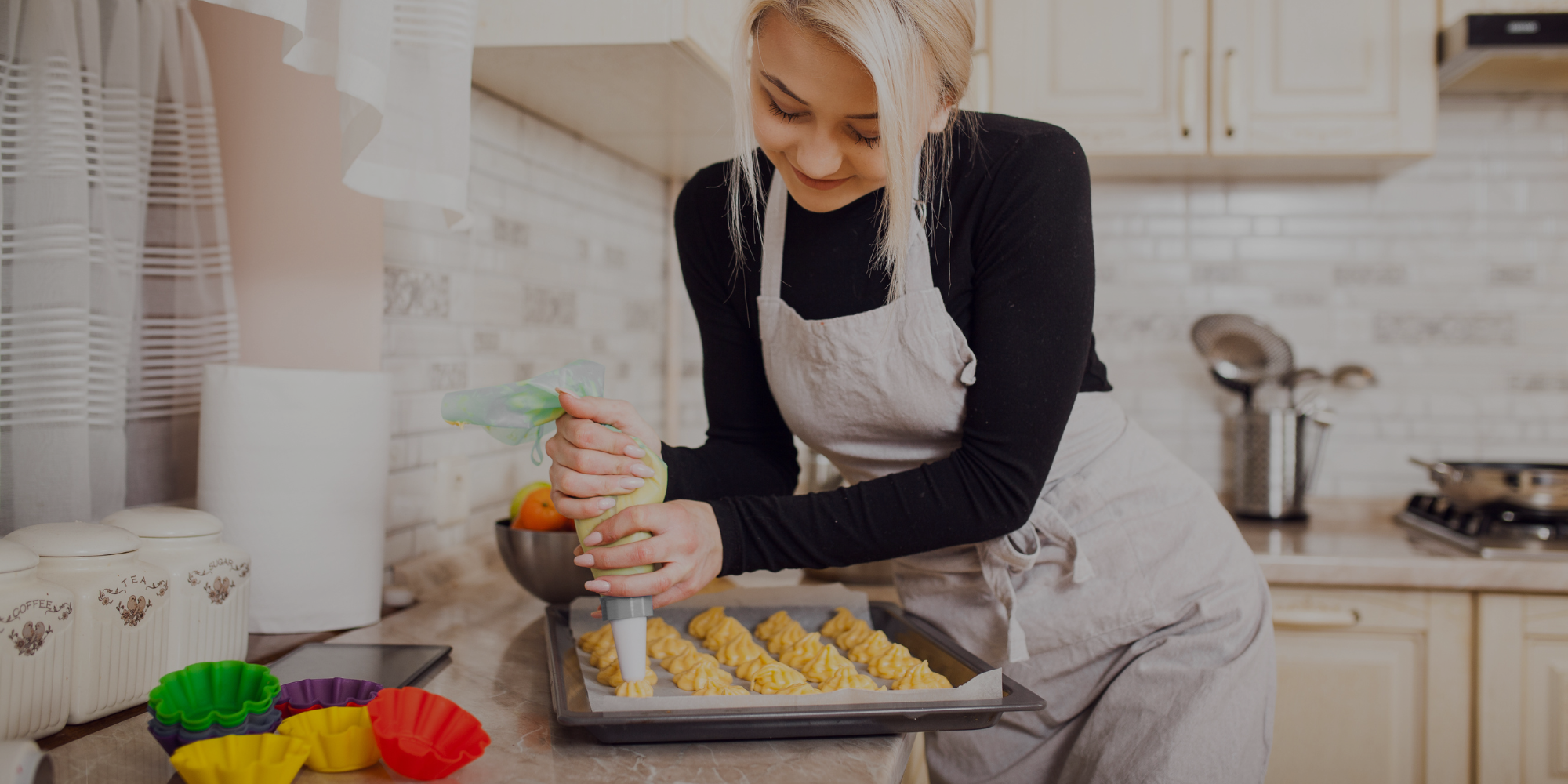 Woman in a kitchen preparing food, wearing an apron.

